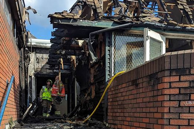 Fire fighters examine the damage to the Watermans Arts Centre